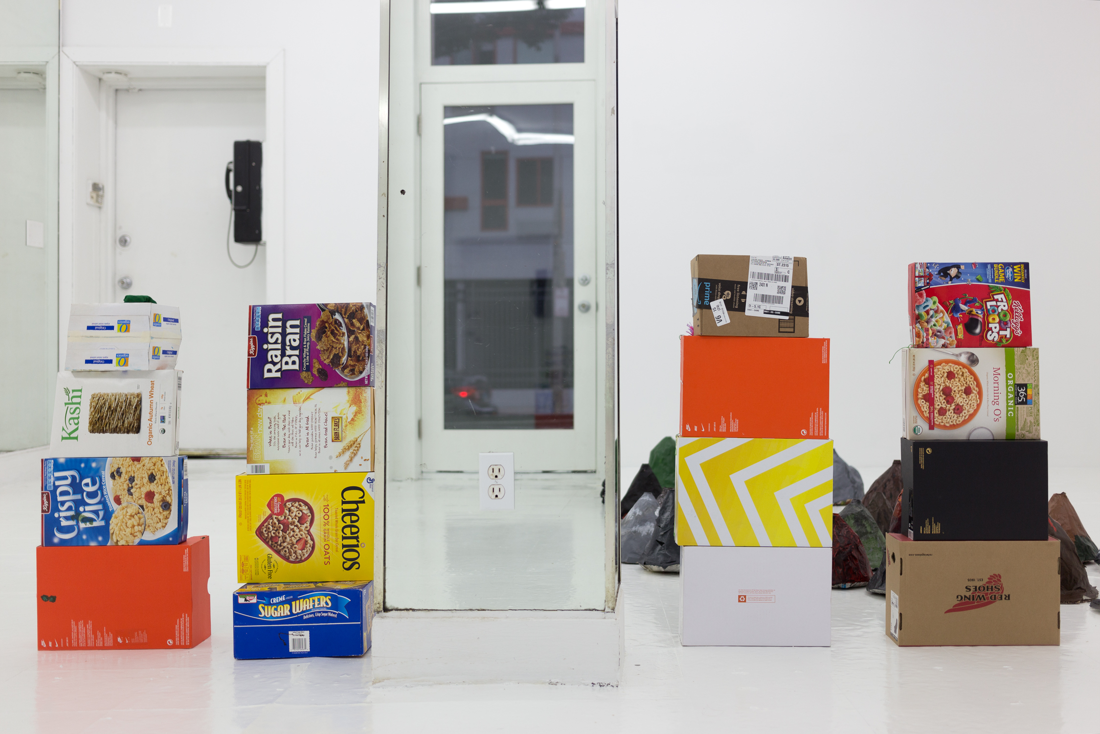 Stacks of cardboard cereal and show boxes, next to a mirrored column