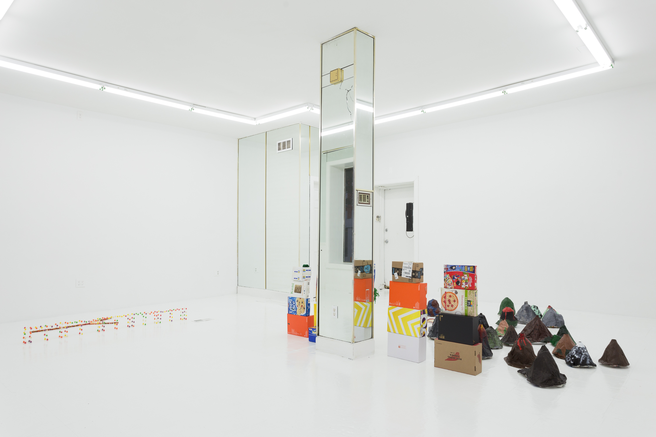 Candy sculptures on the left side of the room, cardboard boxes on the right, separated by column