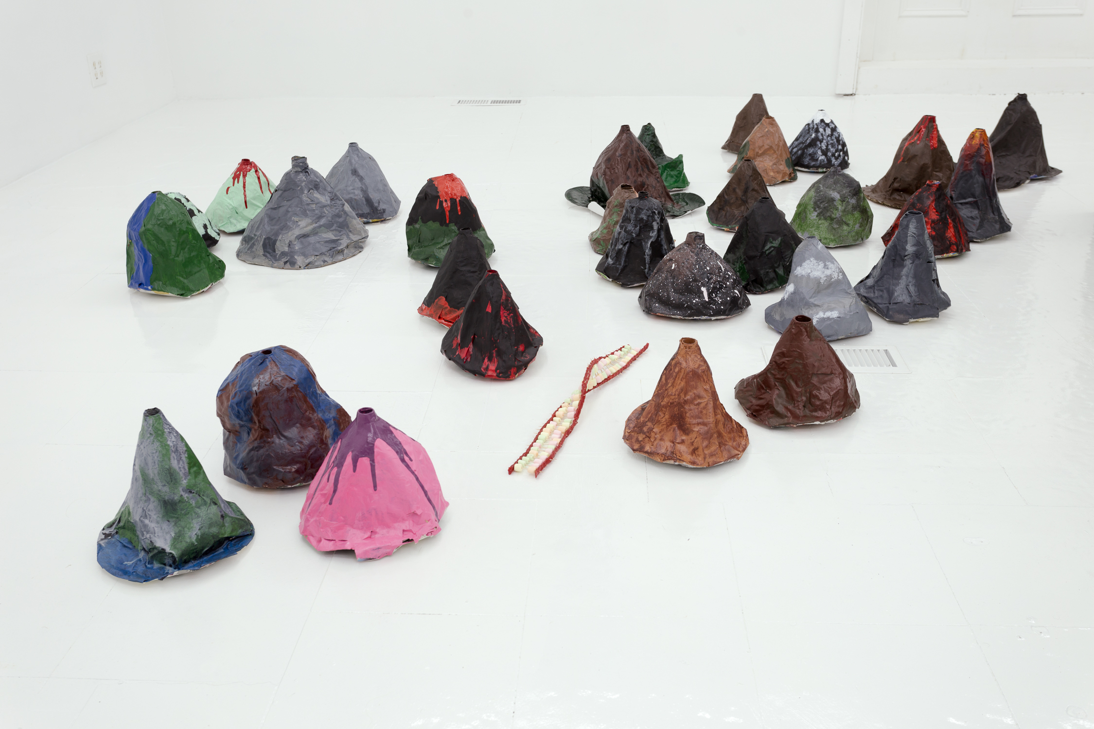 Grouping of papier mache volcanoes, with a twisted candy and toothpick sculpture in the center