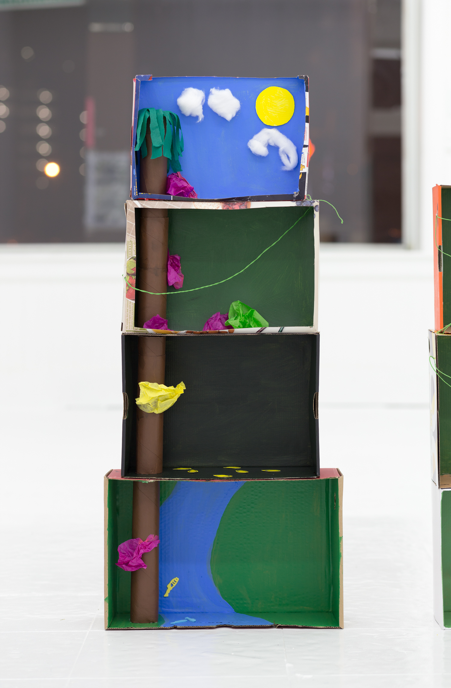 Rainforest diorama made of stacked boxes, toilet paper tubes, and crepe paper