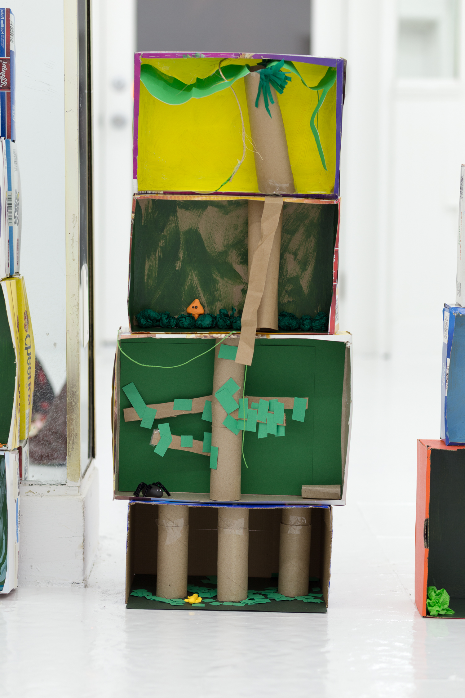 Rainforest diorama made of stacked boxes, toilet paper tubes, and crepe paper