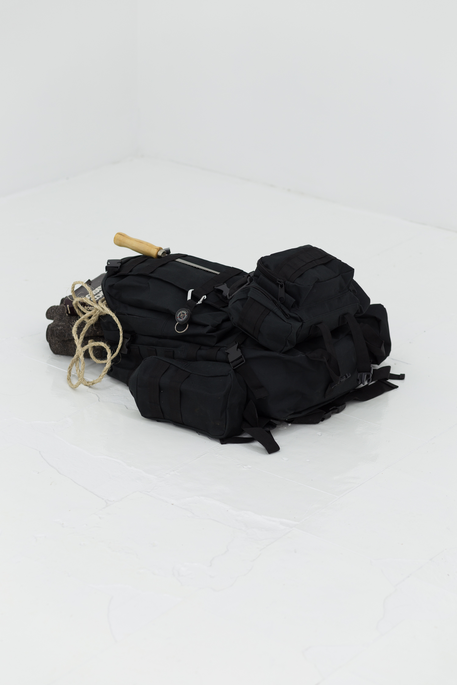 A black technical backpack sits on the floor