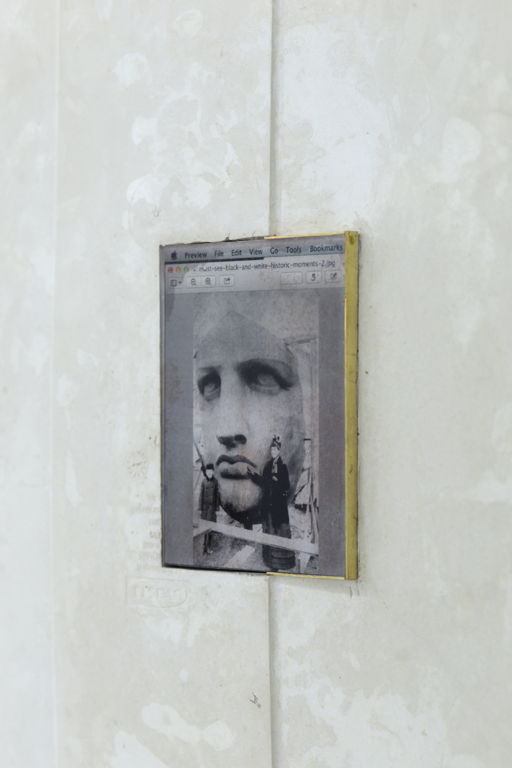 A close up of a photo of the Statue of Liberty's face inset in concrete