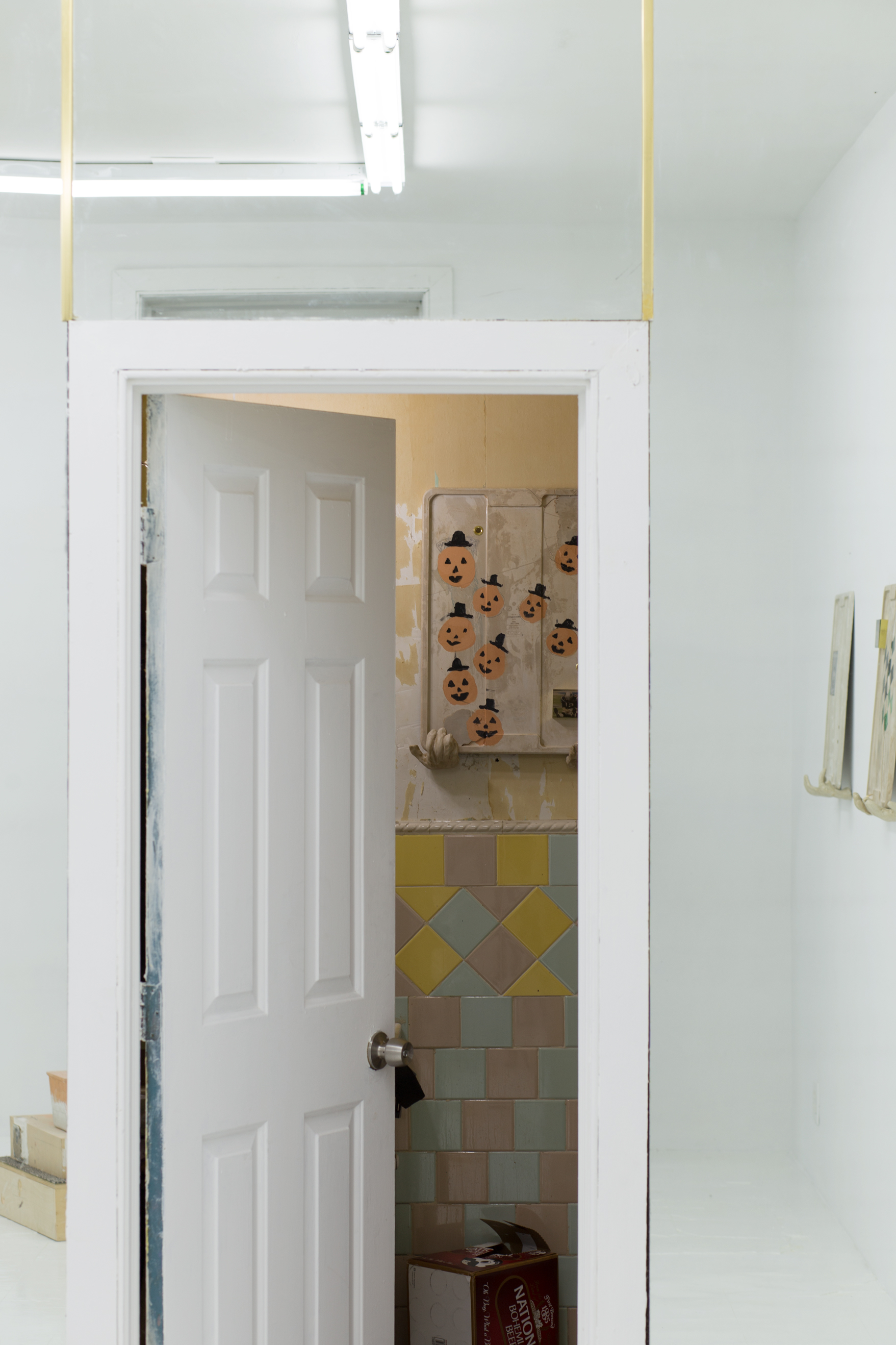 The bathroom door is ajar, revealing another concrete lid; this one is painted with jack-o-lanterns