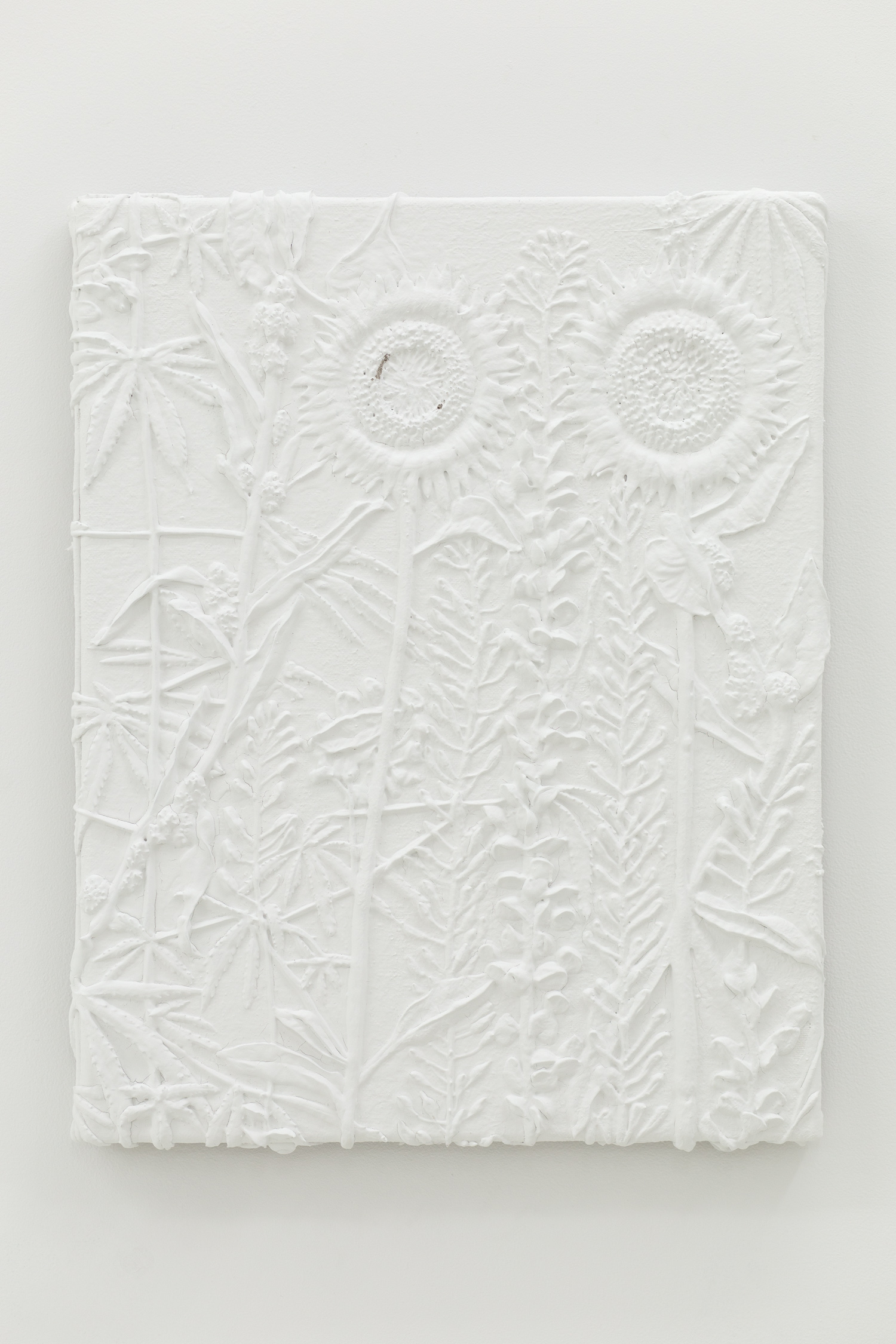 White monotone plastic painting of two sunflowers and assorted other plants