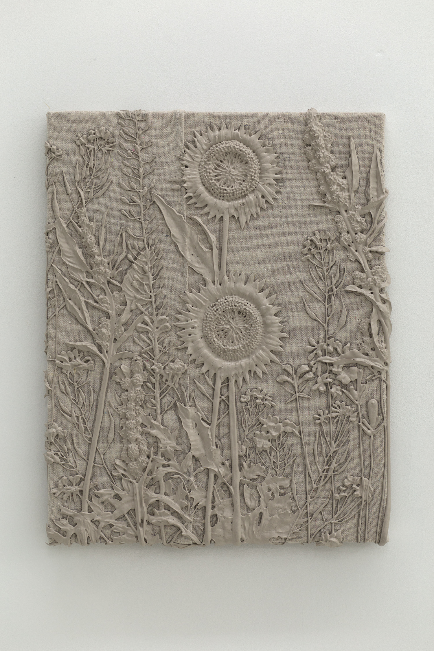 Grey monotone plastic painting of two sunflowers and assorted other plants