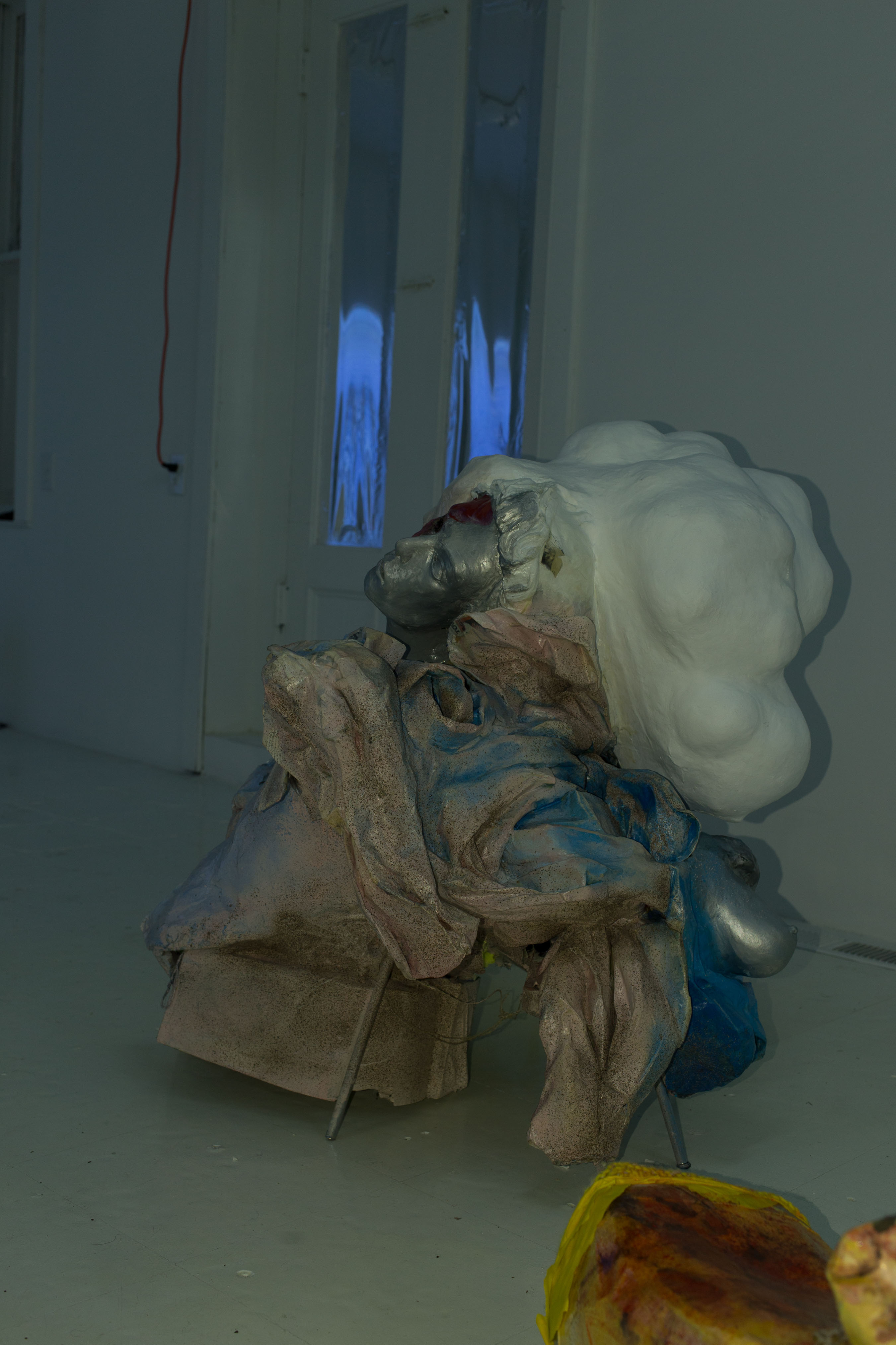 A sculpture by Danica Barboza: a silver face surrounded by a heavy plaster cloud