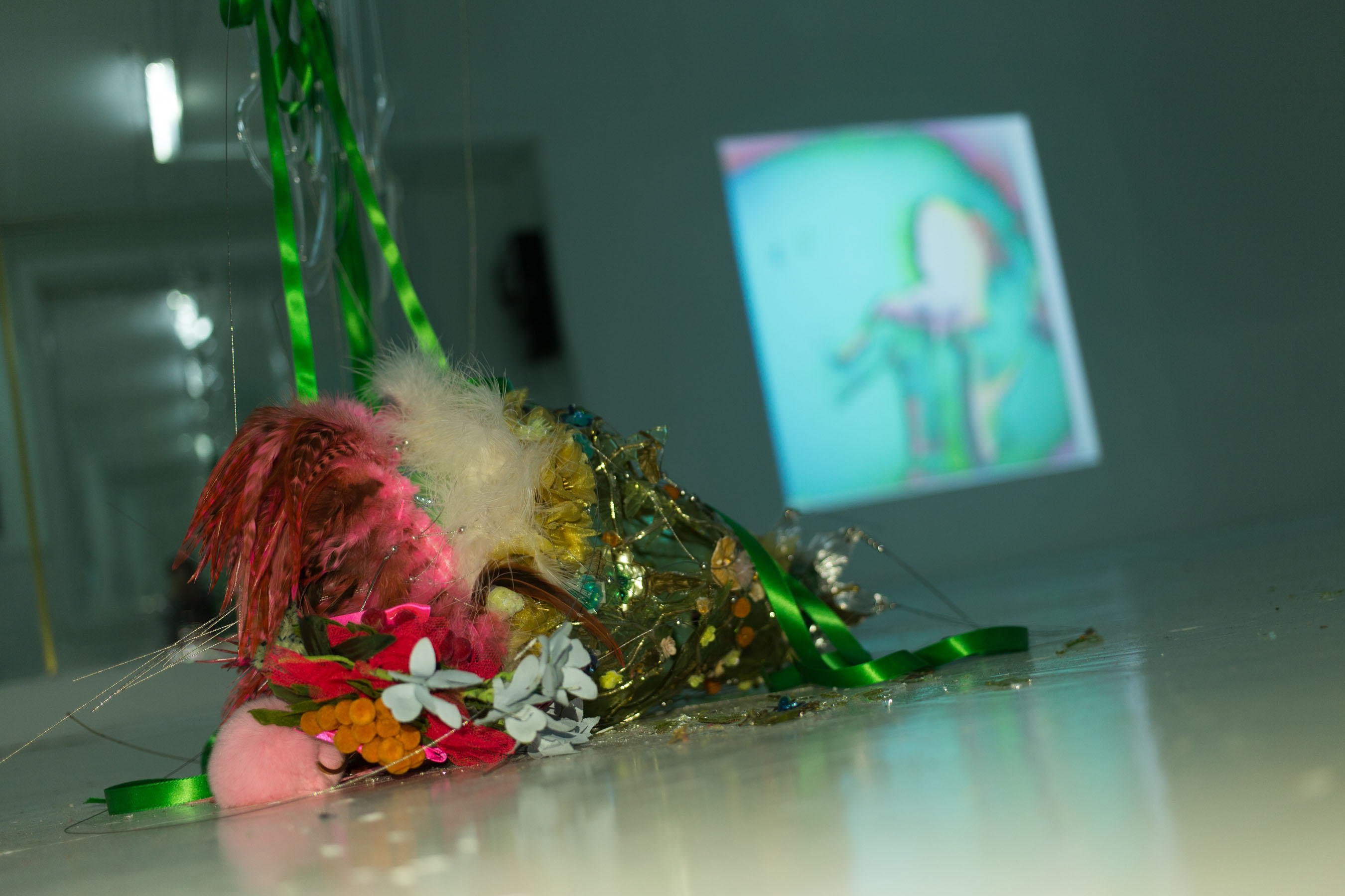 Hanley’s sculpture is covered in flowers, feathers, and shiny fabric