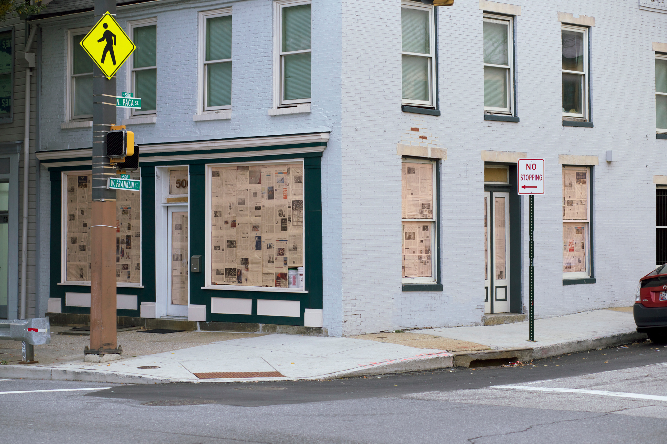 View of the gallery across the street; the windows are covered in pink-tinted newspaper