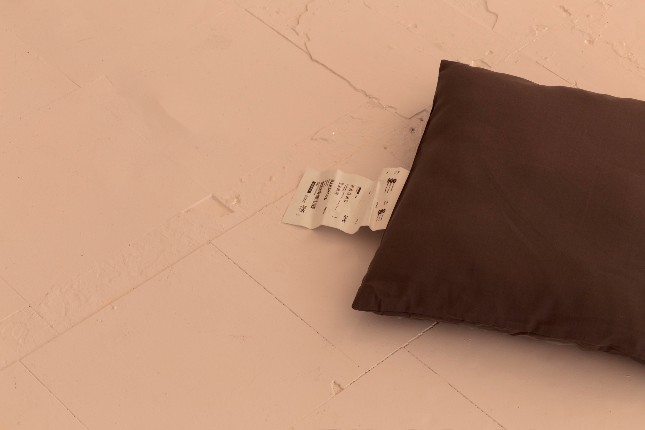 A grey ikea cushion sits on the floor