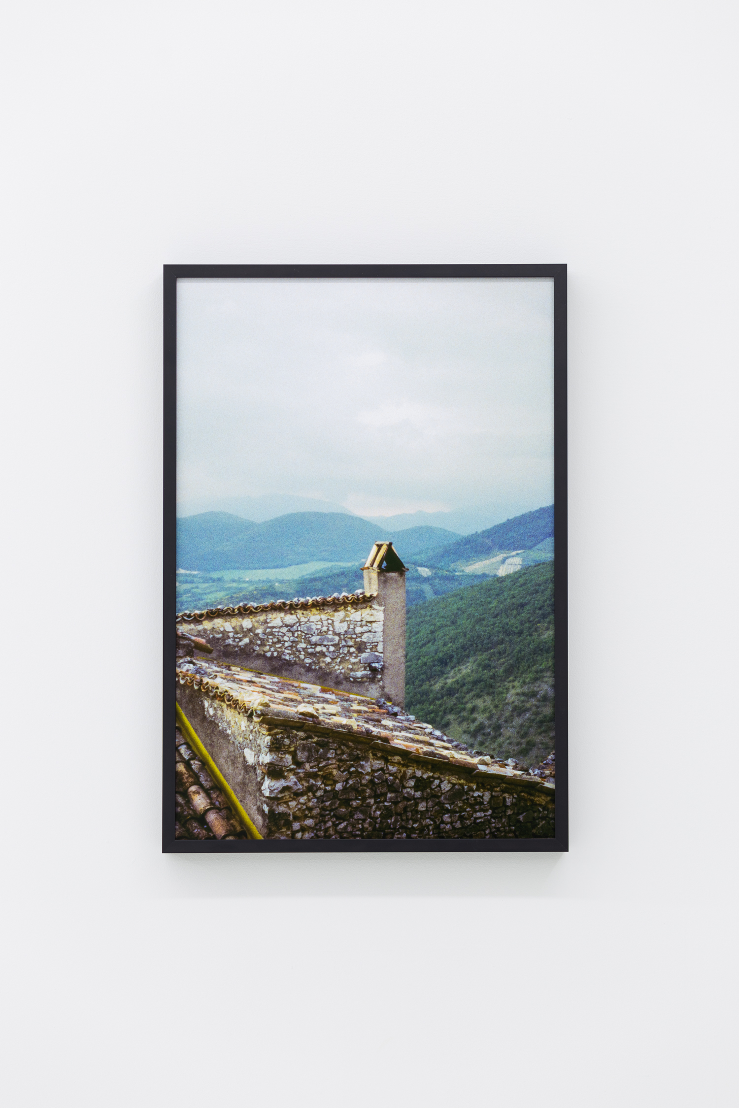 Photo from the roof of an old stone building, with mountains in the background