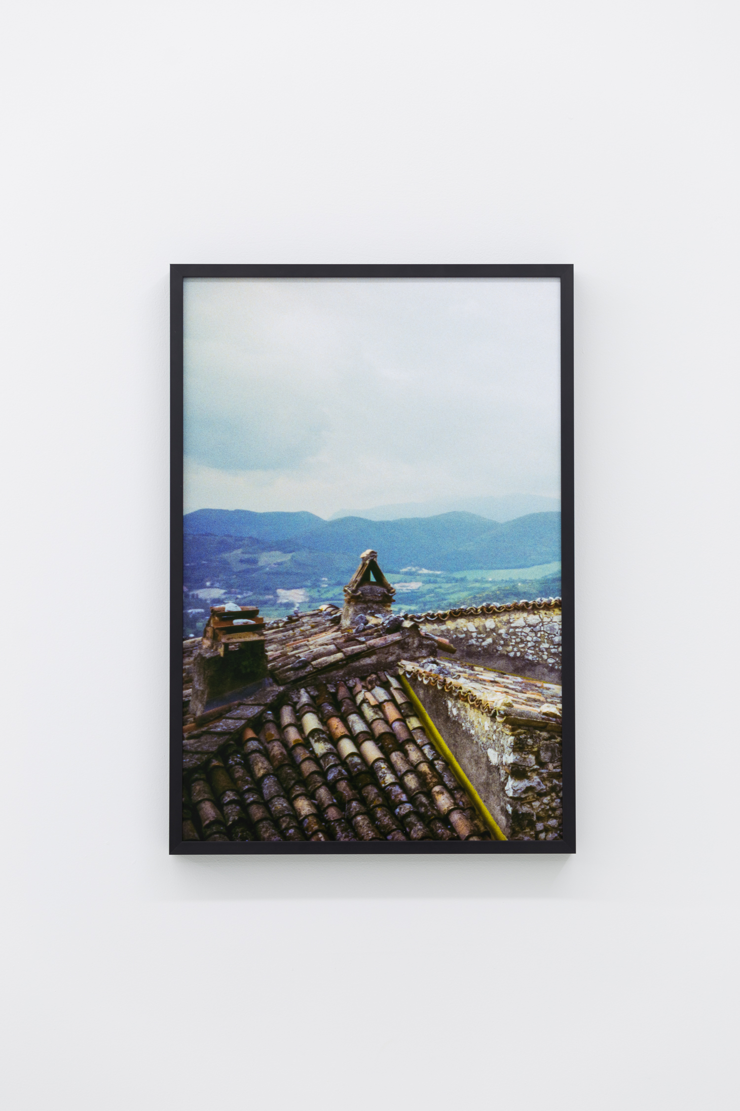 Photo from the roof of an old stone building, with mountains in the background