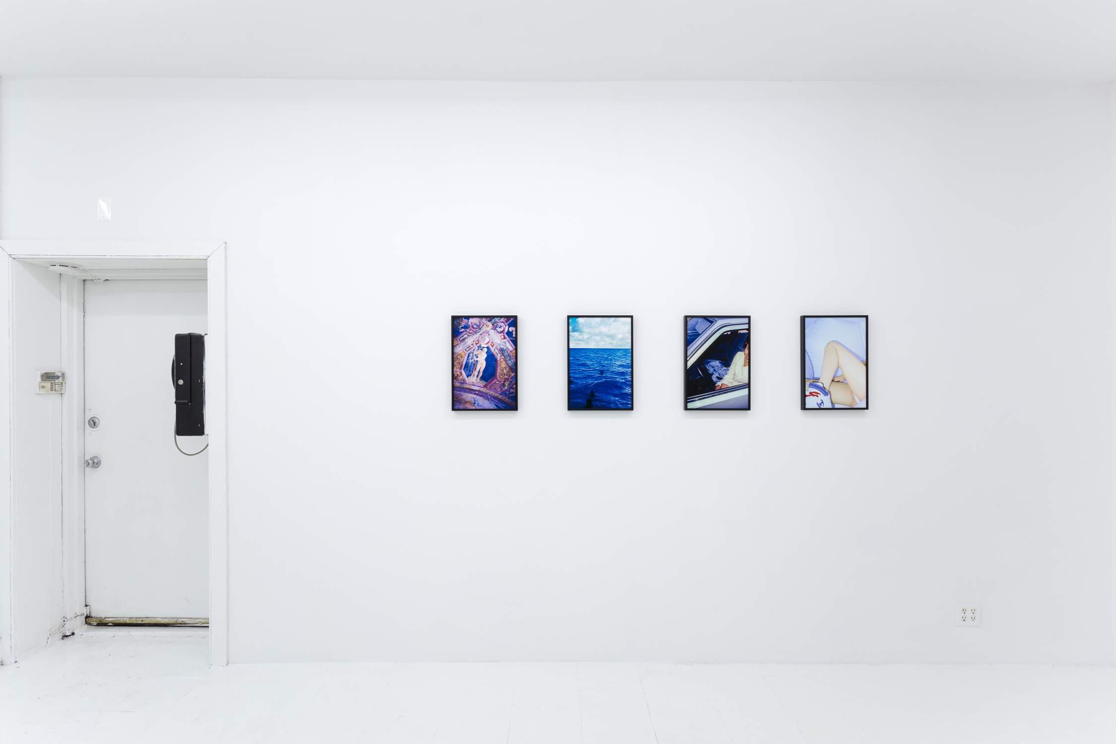 A collection of four photos on the wall; all are blue in tone