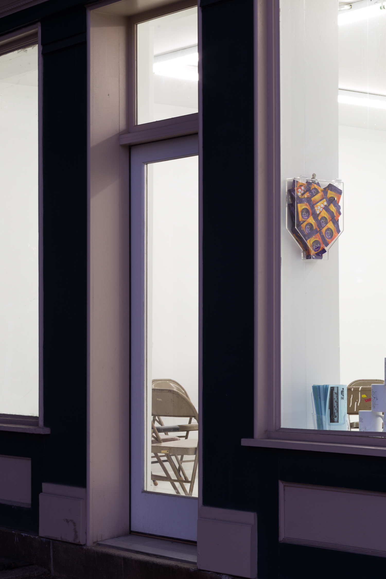 Gallery door and windows, through which a condom dispenser can be seen