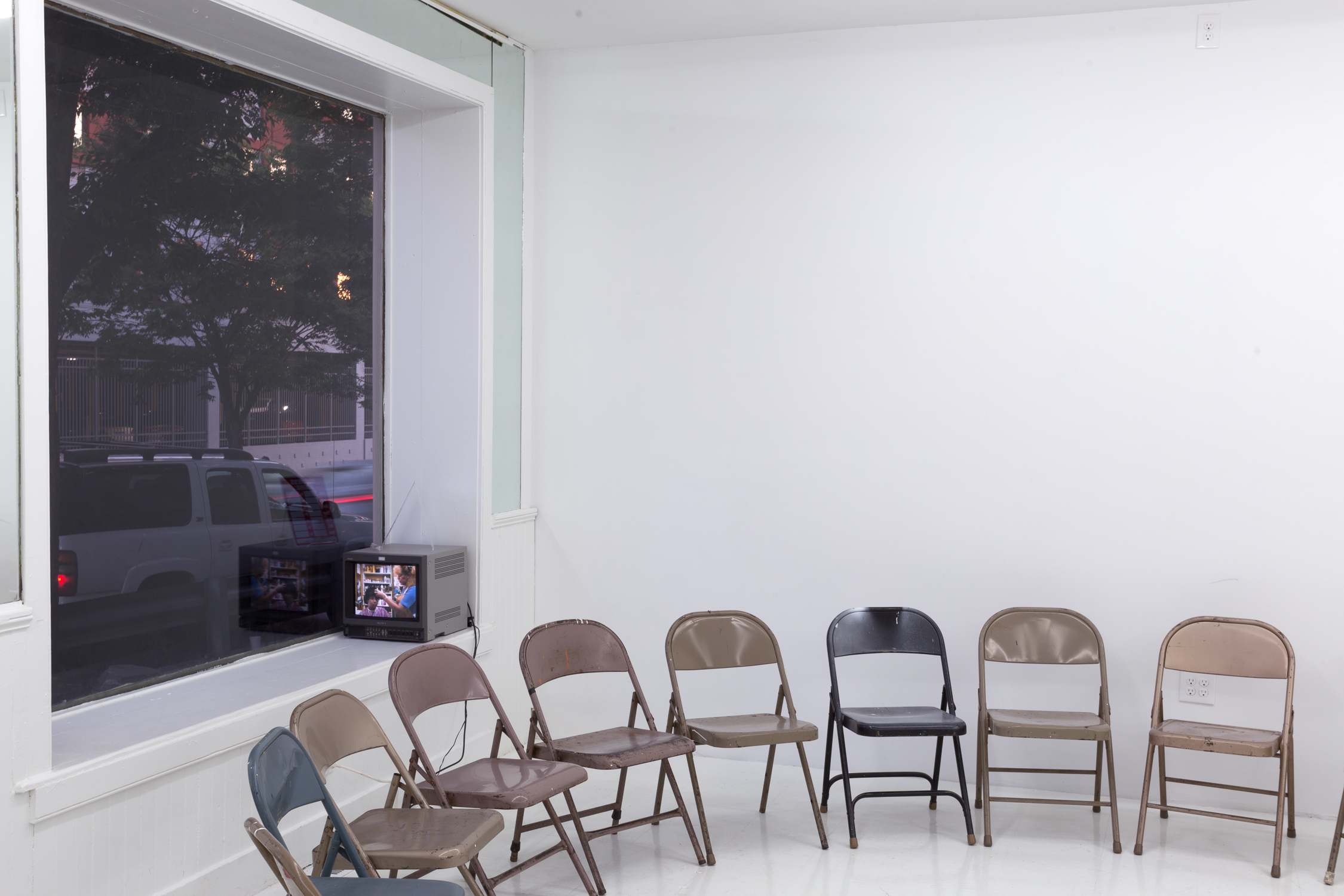 There is a circle of folding chairs in the gallery