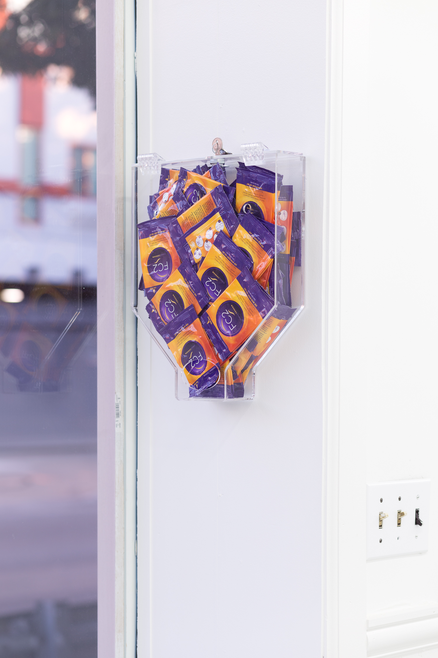 A condom dispenser is affixed to the wall