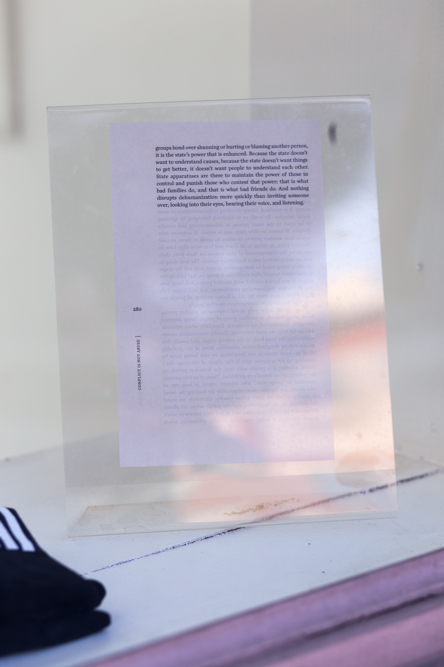 A page from a book is encased in a plastic stand